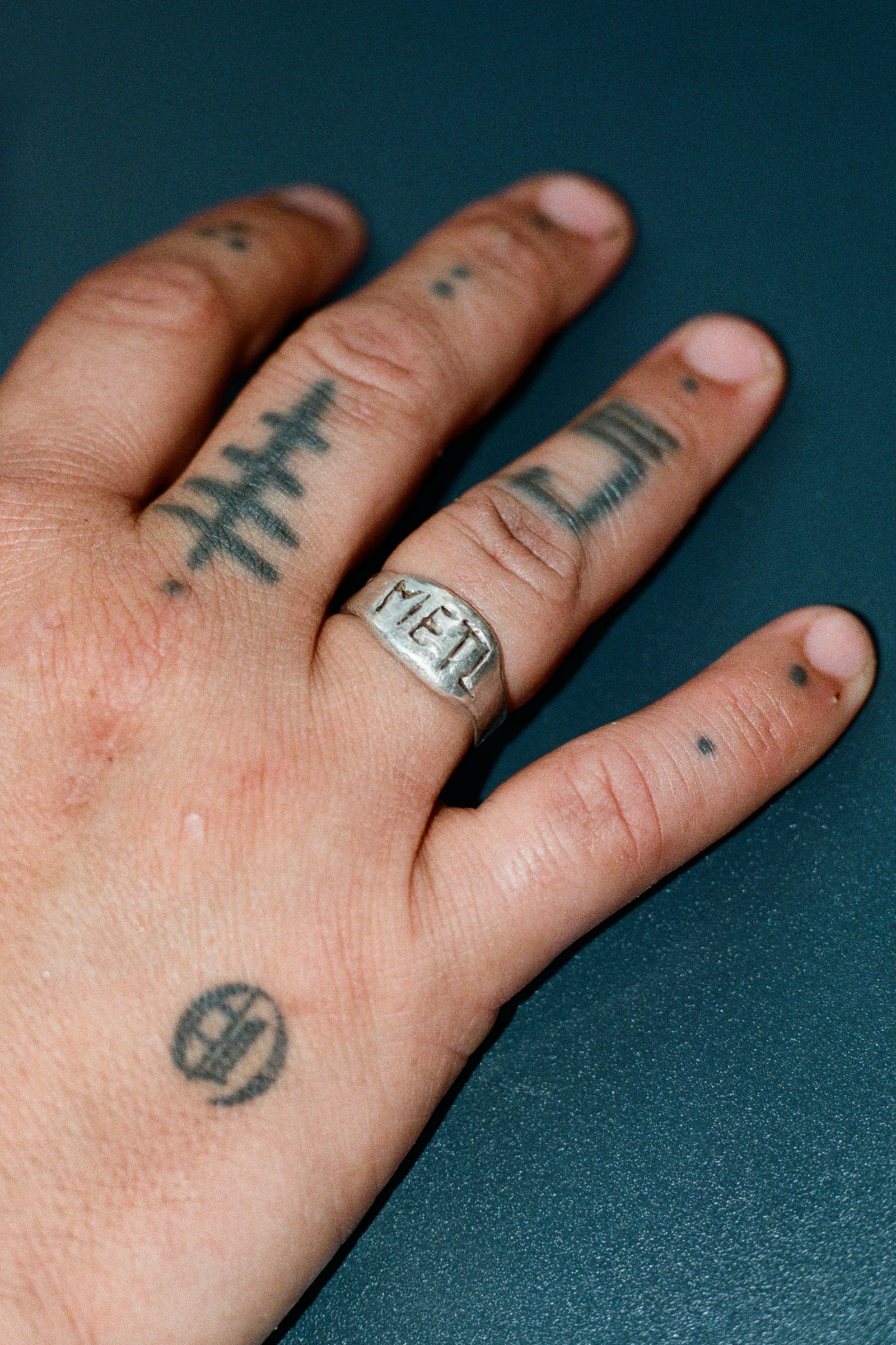 Nudillos tatuados con un anillo de METL