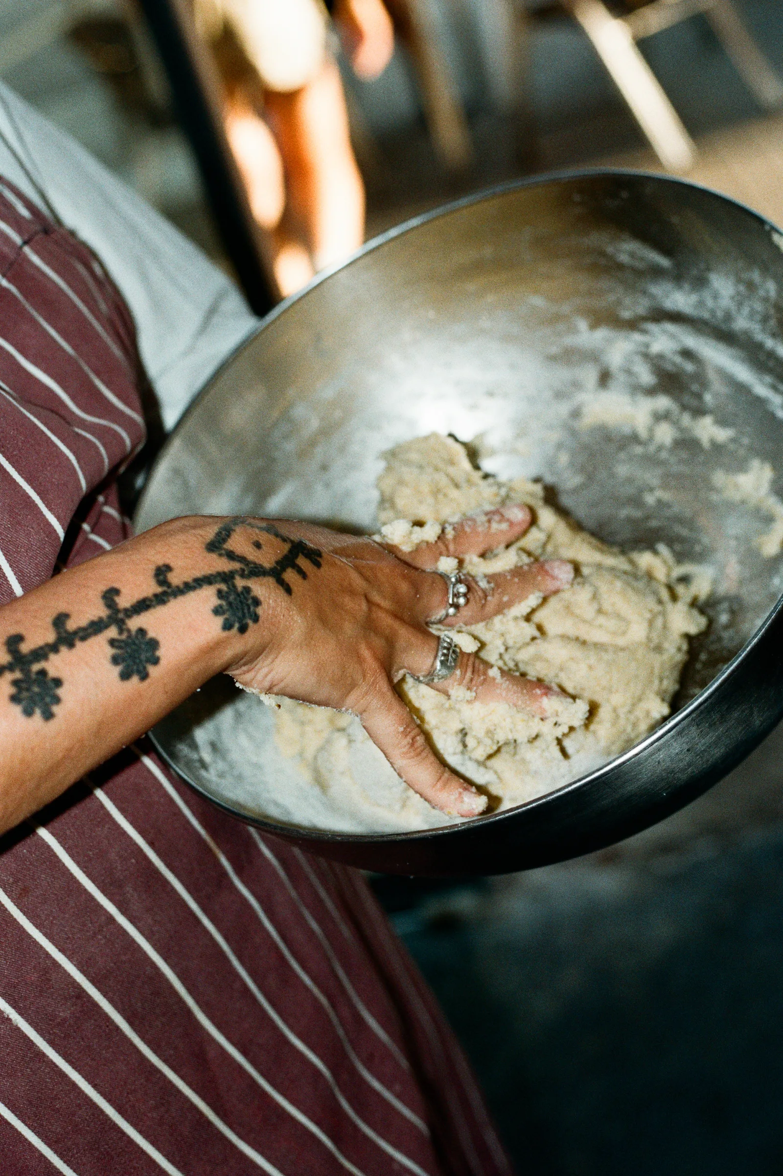 Bol de masa y mano tatuada en la cocina